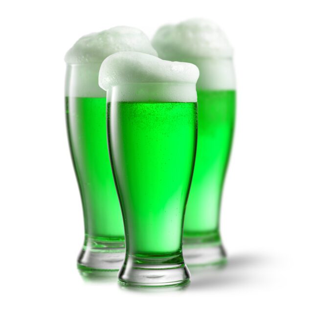 Alcoholic green beer in the glasses on a white.
