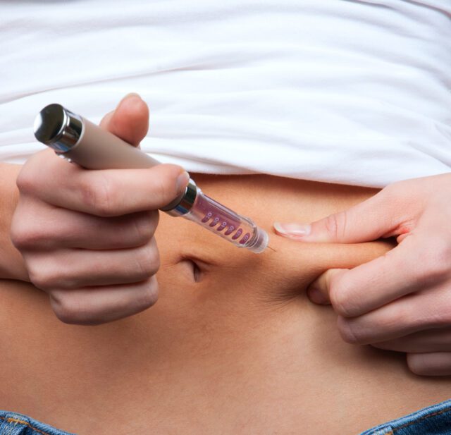 Doctor making diabetes patient insulin shot by syringe