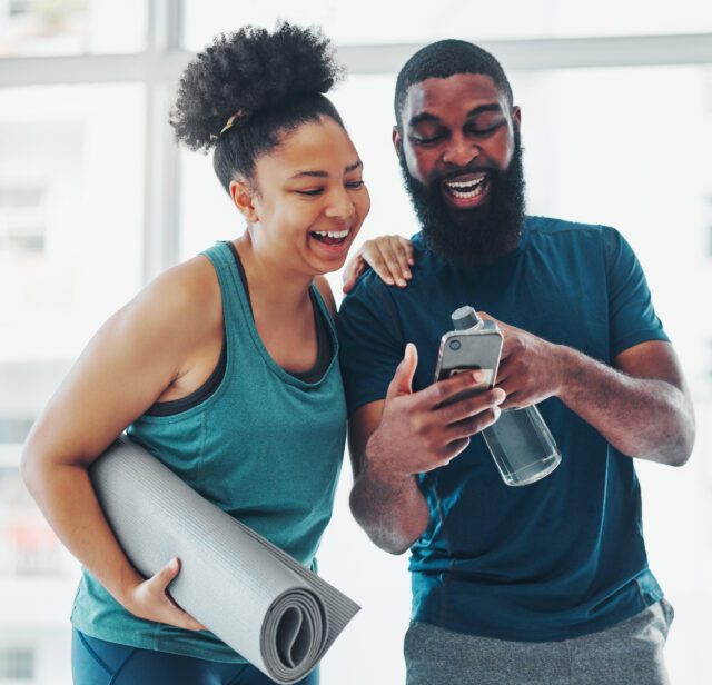 Phone, meme or yoga friends on social media laughing at funny online content after a fitness class. Pilates, black woman and happy African personal trainer relaxing or enjoying crazy comedy together